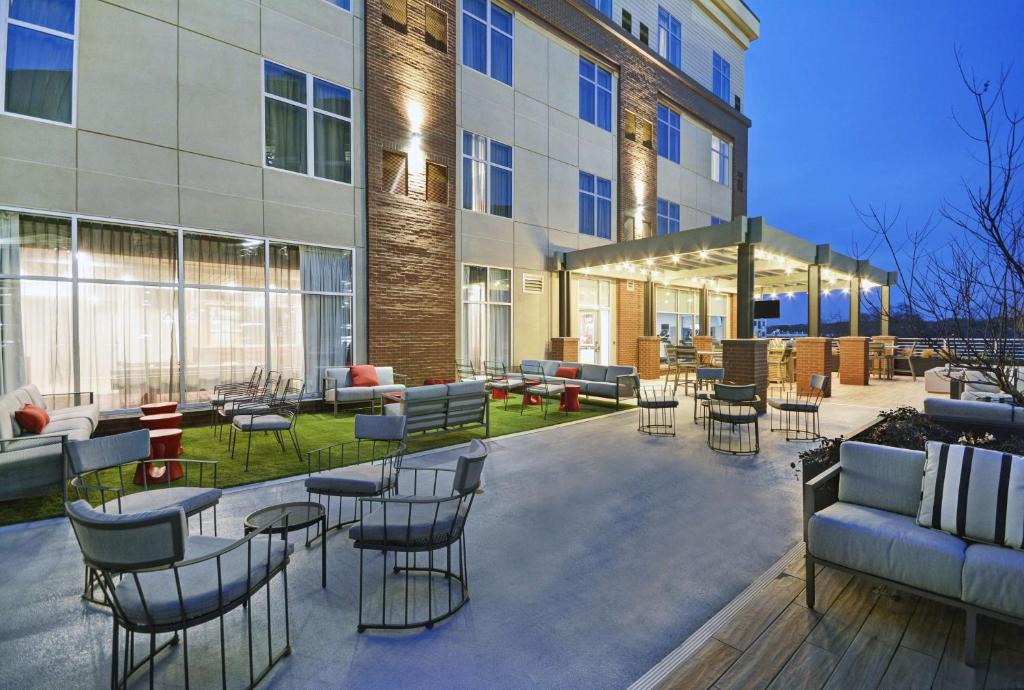 阿森斯Homewood Suites by Hilton Athens Downtown University Area的大楼前带桌椅的天井