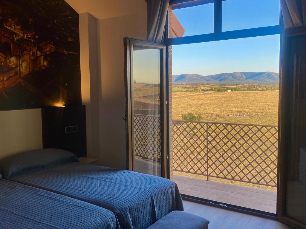 PulgarHotel-Asador Montes Oretanos的一间卧室设有一张床和一个美景窗户。