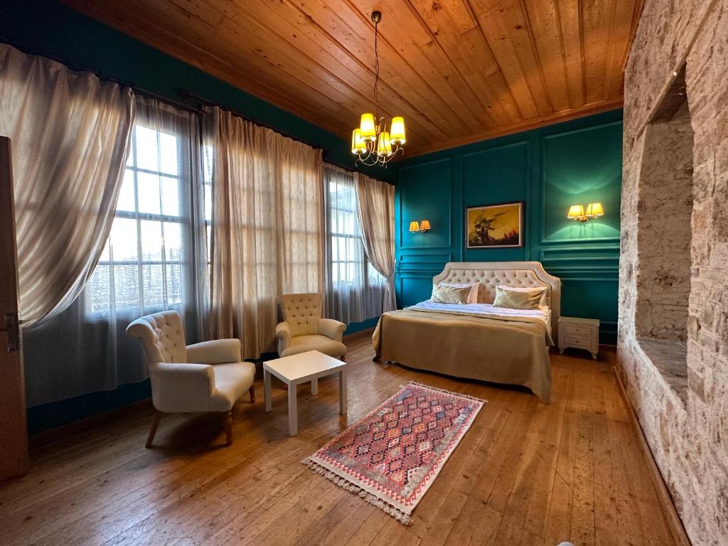 安塔利亚Grace Lounge Suite的卧室拥有蓝色的墙壁,配有一张床和椅子