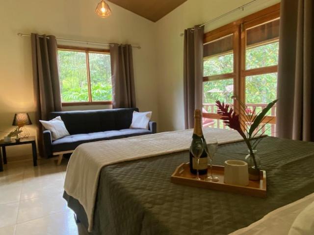 SiquirresSiquirres Mountain Lodge的一间卧室配有一张床和一瓶葡萄酒