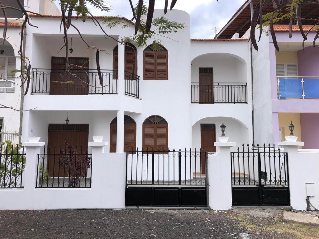 塔拉法尔Tarrafal Ecodécor Full House的白色的建筑,设有棕色的门和栅栏