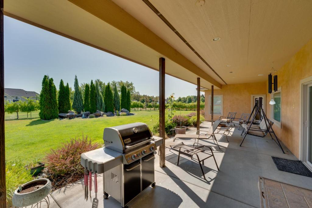 West RichlandWest Richland Home with Vineyard and Mountain Views!的一个带烧烤架和椅子的庭院和一个草坪