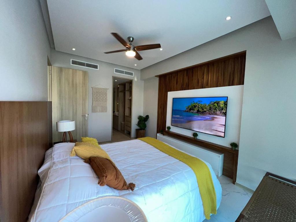 布塞里亚斯Marítima Golf Luxury Department 2BR的卧室配有一张大床,墙上配有电视