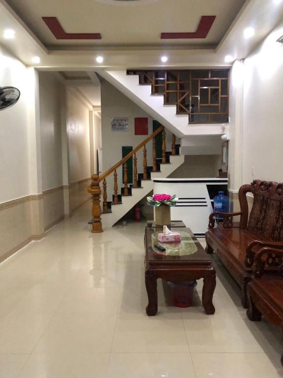 河江Holly's Hostel Ha Giang B&B的带沙发、桌子和楼梯的客厅