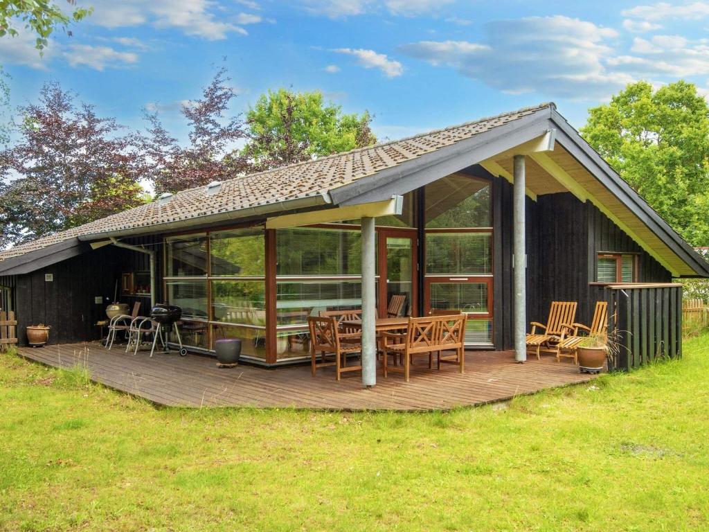 格莱斯堡8 person holiday home in Glesborg的房屋设有1个带桌椅的甲板