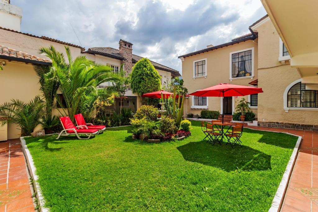 基多拉卡图加酒店的一个带红色椅子的院子和雨伞