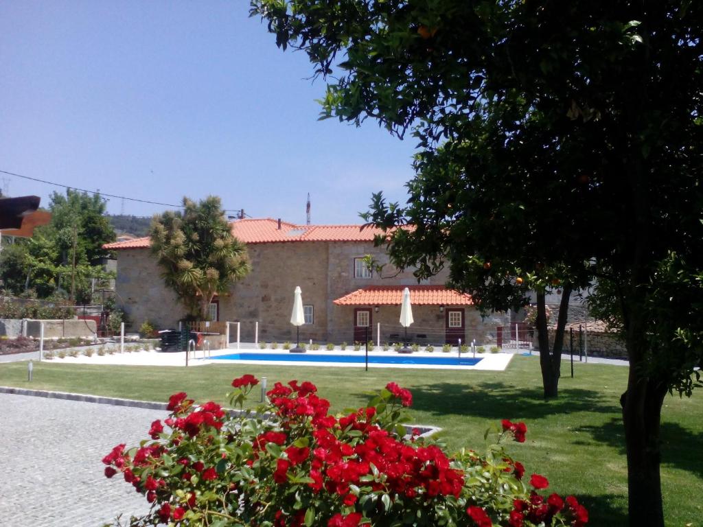 布拉加Casa Cachada的一座带游泳池和红花的建筑