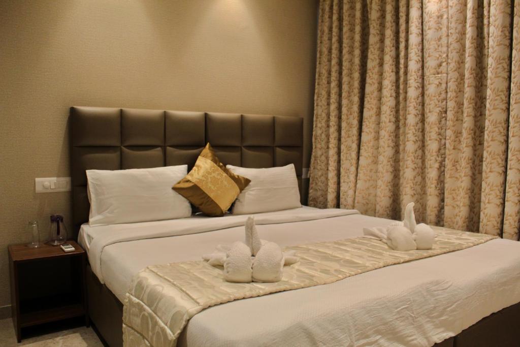 孟买Maxxvalue Apartment Hiranandani Powai的酒店客房,配有一张带两只兔子的床。