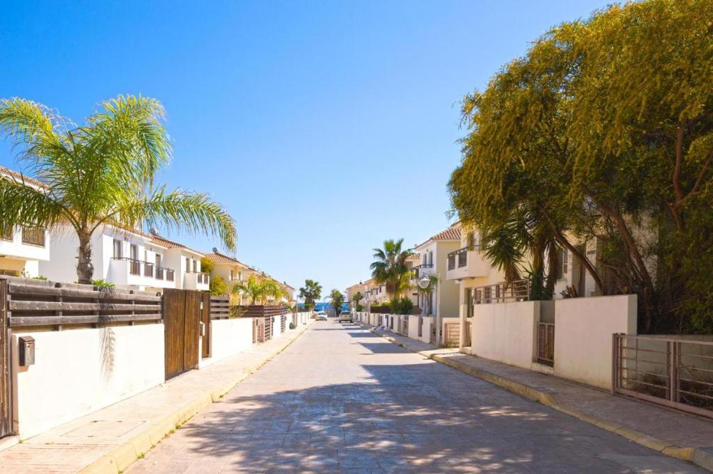普罗塔拉斯Yama's Villa - Polyxenia luxury, protaras, cyprus的一条棕榈树和建筑的空街