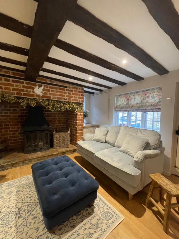 GodmanchesterHistoric Cambridgeshire Cottage的带沙发和壁炉的客厅