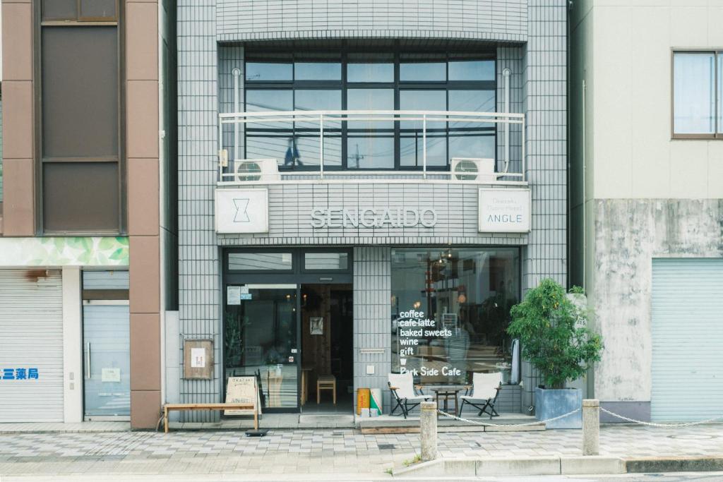 冈崎市Okazaki Micro Hotel ANGLE的建筑物前面的商店,上面有标志