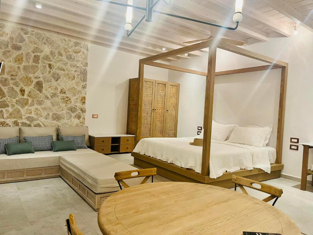锡米Nisomar Suites的一间卧室设有两张床和一张木桌
