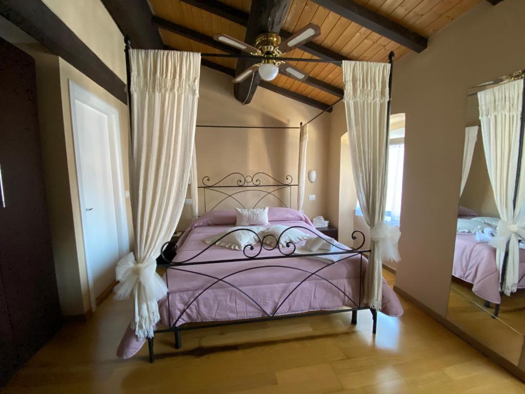 萨尔扎纳皮亚泽塔住宿加早餐旅馆的一间卧室配有一张紫色的床和吊扇