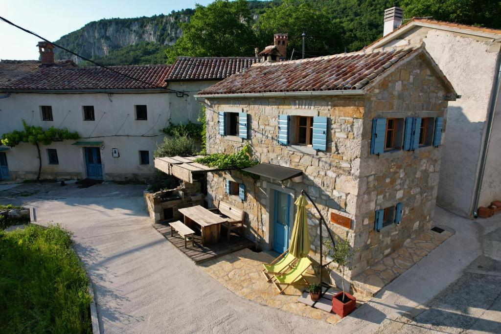 罗克Mountain Lodge Istria, Tiny house的一座古老的石头建筑,前面设有野餐桌