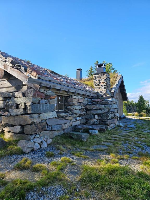 弗洛Hytte i Hallingdal/Flå的田边的古老石屋