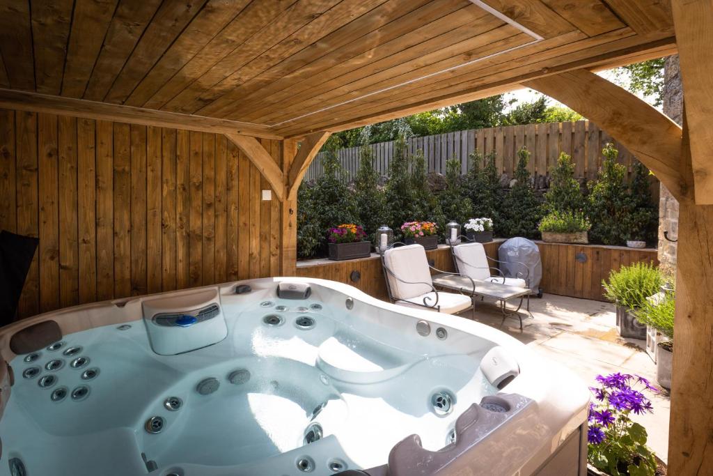 BledingtonCotswold cottage with hot tub的庭院中央的按摩浴缸