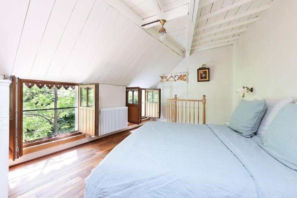 安特卫普Carriage House in quiet ecological garden的一间卧室设有一张大床和一个大窗户
