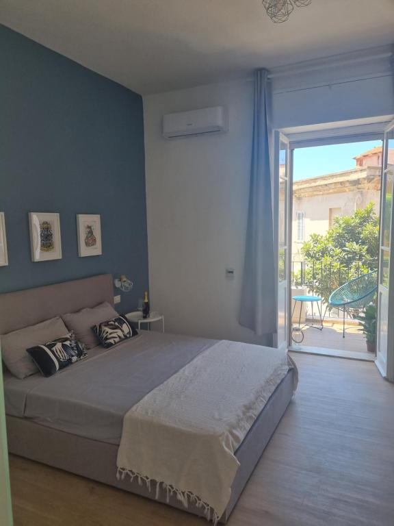 卡利亚里Sunset 221 Cagliari的一间卧室设有一张床和一个滑动玻璃门