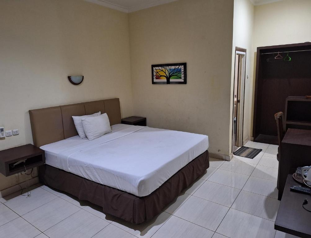 岩望Makati Pasuruan Hotel的一间卧室,卧室内配有一张大床