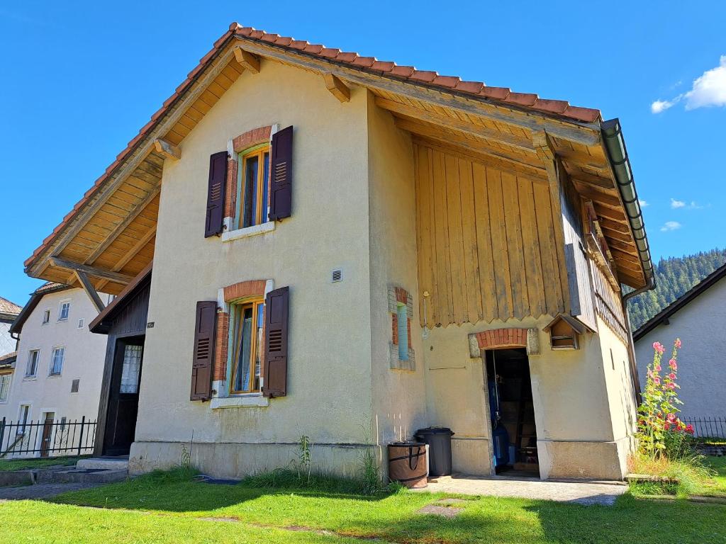 Les VerrièresCharmante maison individuelle的一间白色的小房子,设有棕色百叶窗