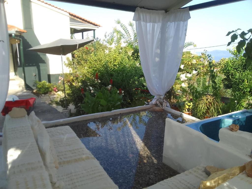 AgriovótanonEloise的庭院设有游泳池和带遮阳伞的桌子。