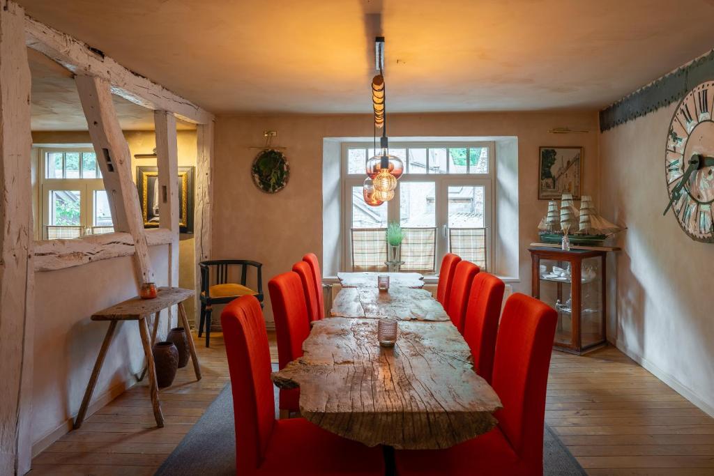 杜柏Le Nid de la Canette的一间带长桌和红色椅子的用餐室