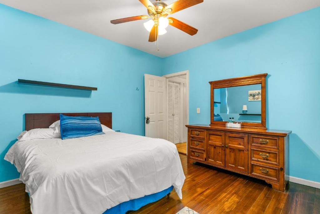 布里奇波特The Blue Room near Yale Hospital/Bridgeport的一间卧室配有一张床、镜子和吊扇