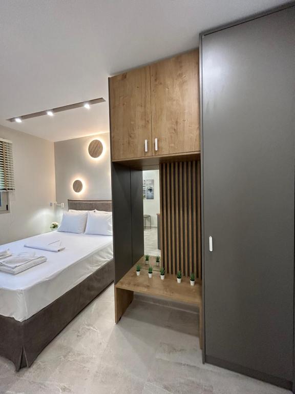 依拉佩特拉Armonía Small Luxury Apartments的一间卧室配有一张大床和一个木制橱柜