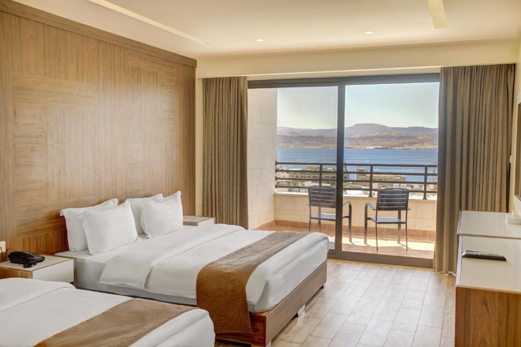 亚喀巴Luciana Hotel by BRATUS的酒店客房设有两张床和一个阳台。