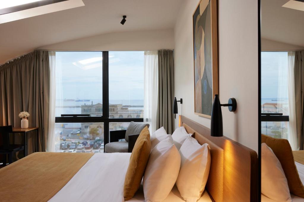 塞萨洛尼基Noa Hotel的酒店客房设有一张带大窗户的床。