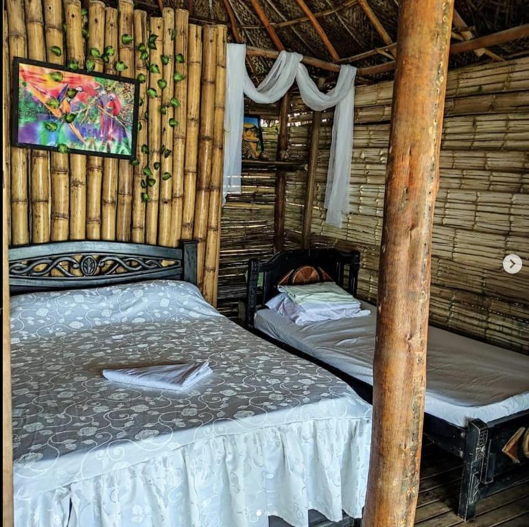 GuachacaHostal Paraíso的小木屋内一间卧室,配有两张床