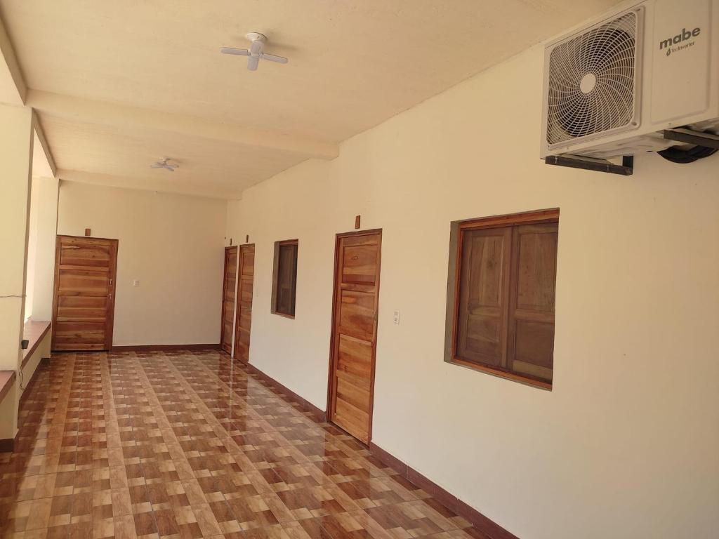 SuchitotoHostal las 3 J的空空房间,设有白色的墙壁和木地板