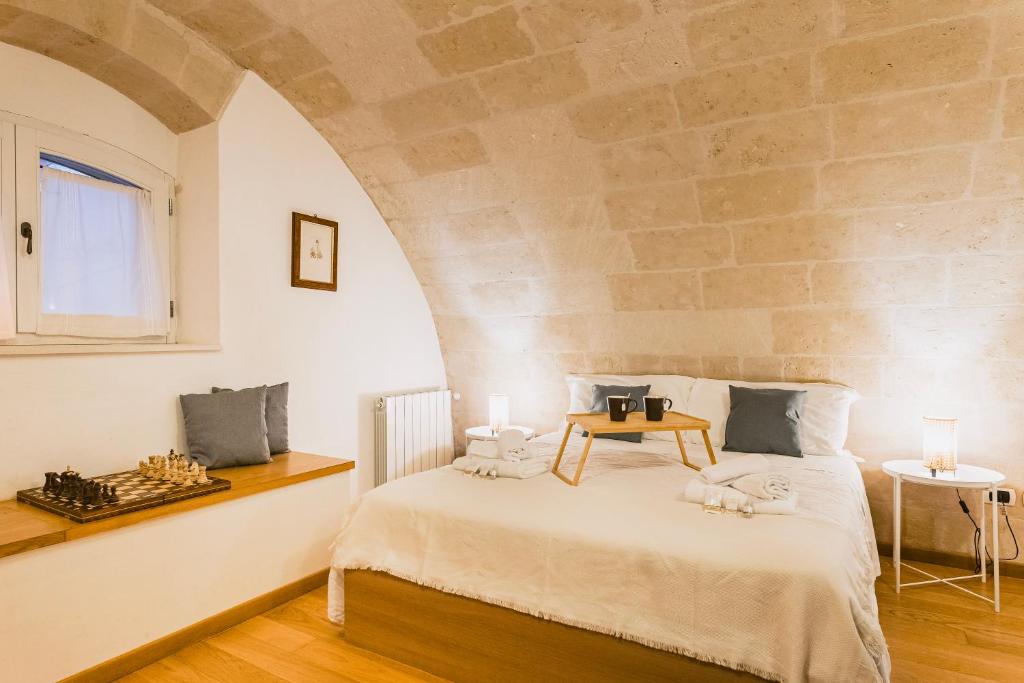 马泰拉[Sassi-Suite]- Aura - Matera的一间卧室设有一张带石墙的大床