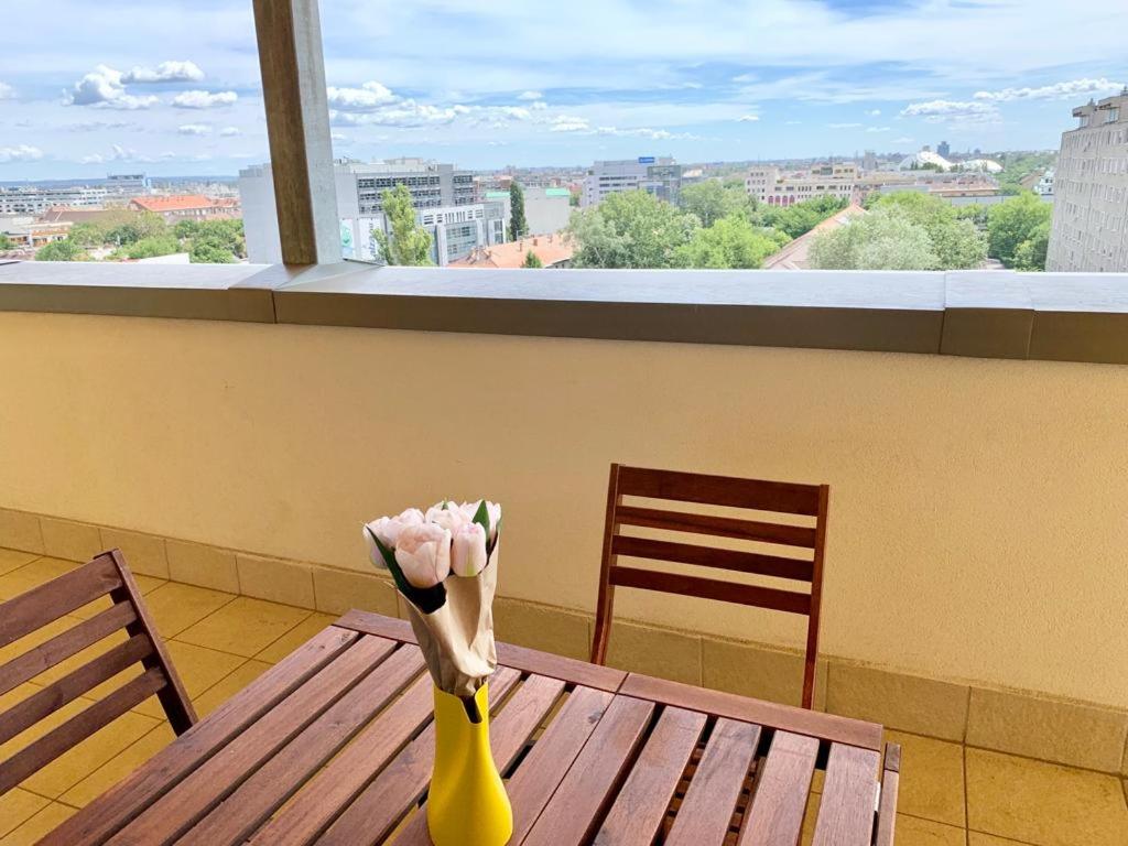布达佩斯Penthouse Young #freeparking的黄色的花瓶坐在木桌边,窗户