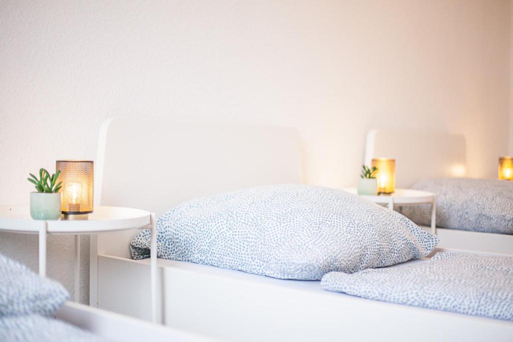 多特蒙德DO One Bedroom Flat的一间卧室配有一张床和两张带蜡烛的桌子。