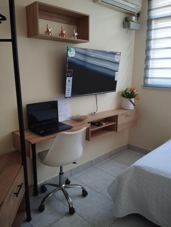 曼塔Posada del sol的一间卧室配有一张带笔记本电脑和电脑显示器的书桌