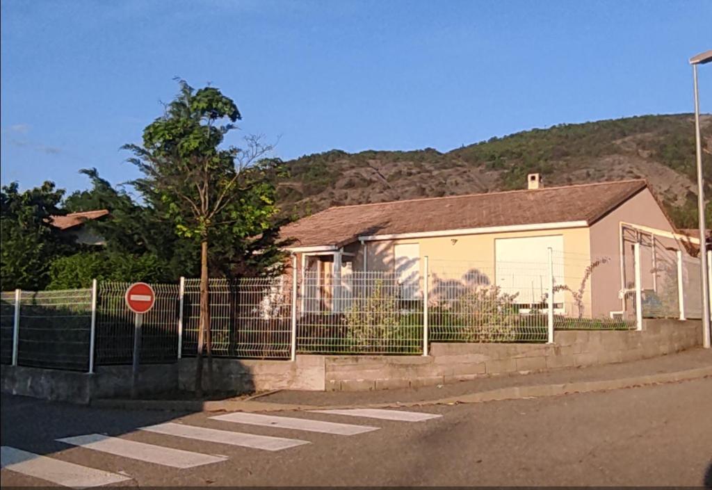塔拉尔Chambre chez l'habitant "Entre Airs et Montagnes"的前面有围栏的房子
