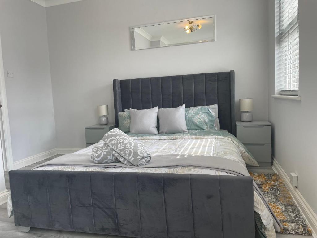 坎伯利Luxury 2 bedroom maisonette with private garden, fibre WIFI, Sky channels的一间卧室配有一张大床和黑色床头板