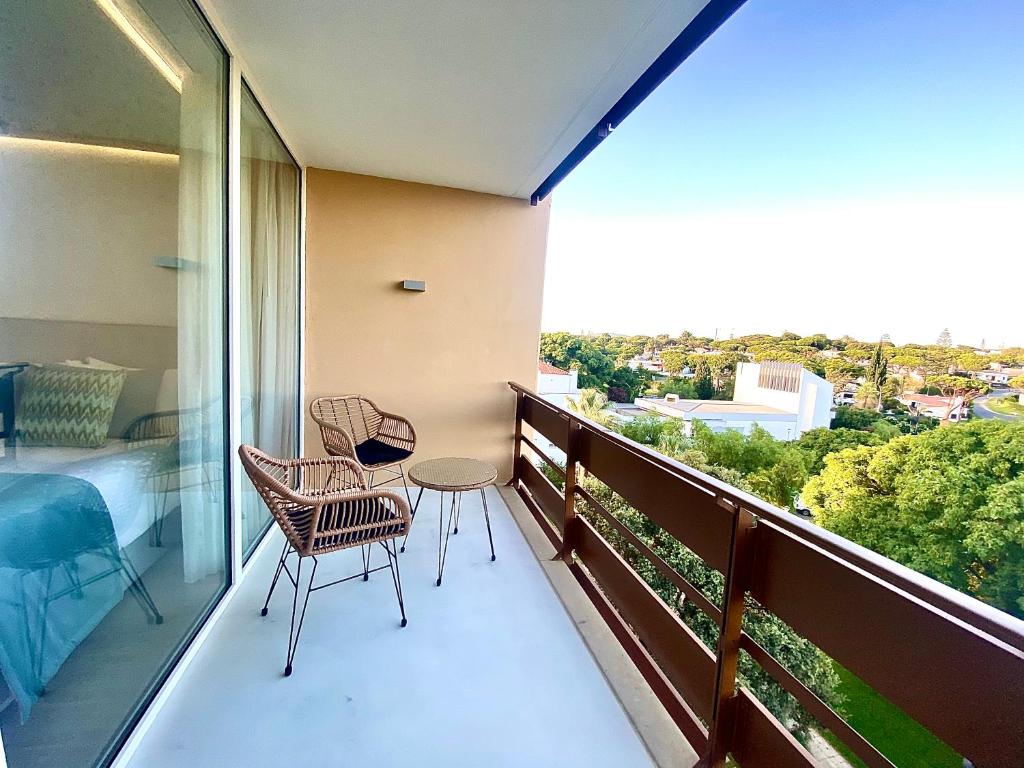 维拉摩拉Marina Walk Apartment的阳台配有两把椅子、一张桌子和一张床