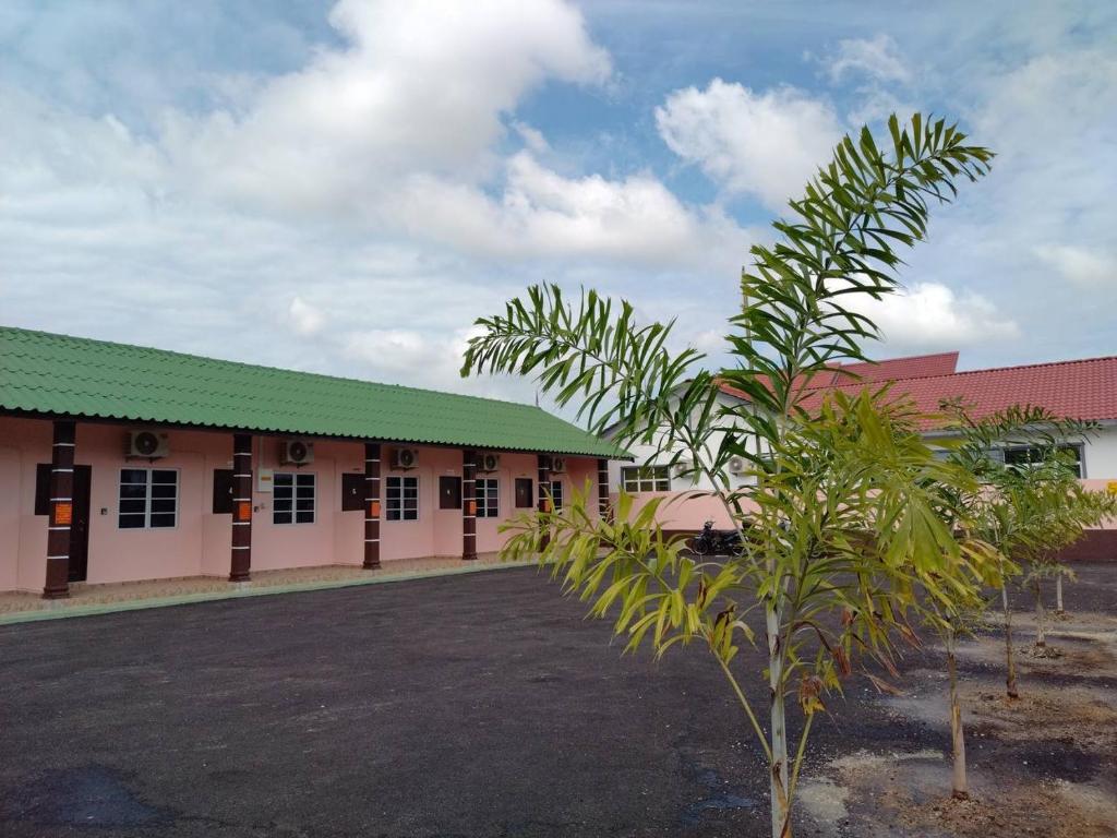 Kampong Balai MarasChalet Sri Bayu的前面有棕榈树的建筑