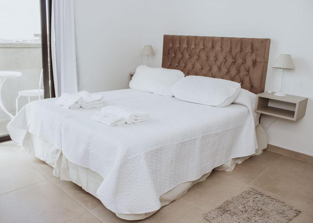 圣米格尔·德·图库玛Yellow的白色的床,配有白色床单和白色毛巾