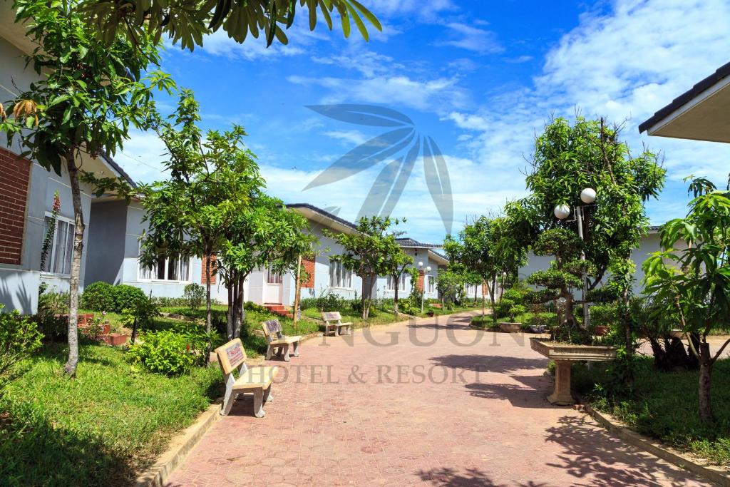 Hưng LongTre Nguồn Thiên Cầm Hotel&Resort的公园里长着长椅和树木的走道