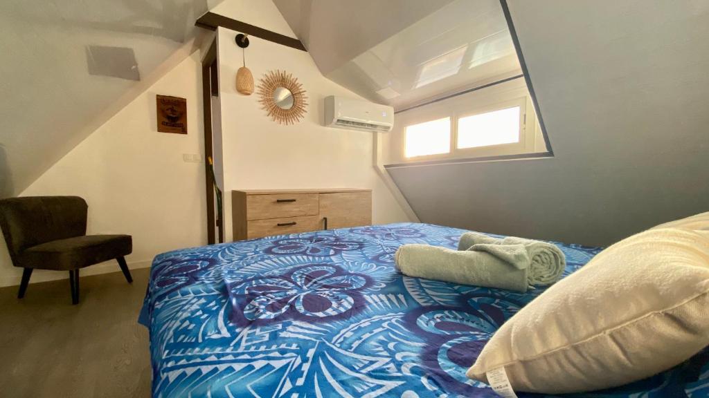 普纳奥亚Vanakea Beach House的一间卧室配有一张带蓝色棉被的床和窗户。