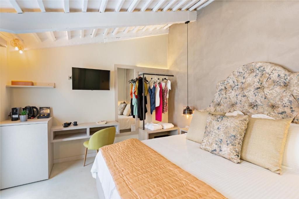 罗希姆诺Mitos-Suites的一间卧室配有一张床,并在一间客房内配有电视。