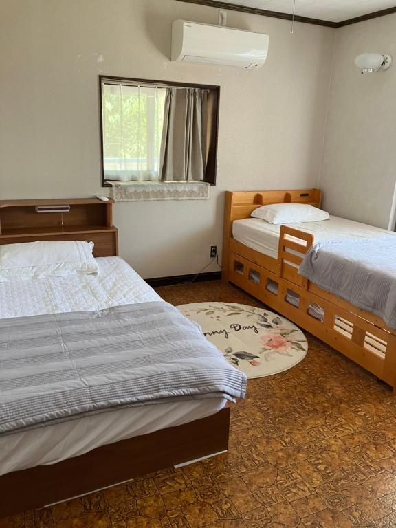 郡上市癒しのwonderland 泉的一间卧室设有两张床和窗户。