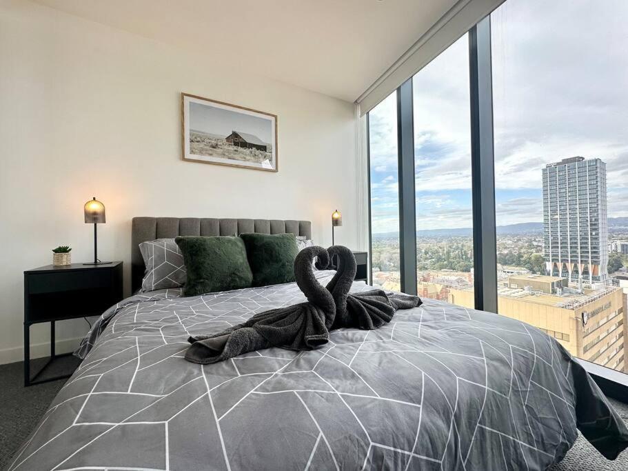 阿德莱德Luxury Top Level 1 Bedroom Apartment with Stunning View in Adelaide CBD - 1 minute walk to Rundle mall - Free Wifi & Netflix的一间卧室配有一张大床,上面有天鹅