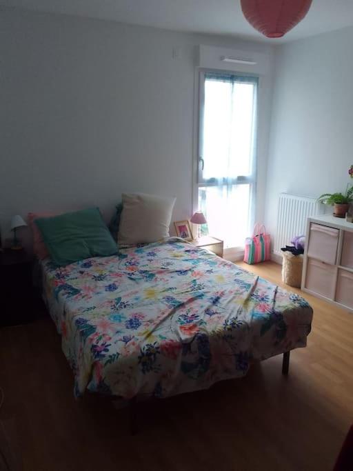 阿尔福维尔Chambre pour deux personnes dans un logement partagé Two persons room in a shared apartment的一间卧室配有一张带五颜六色棉被的床