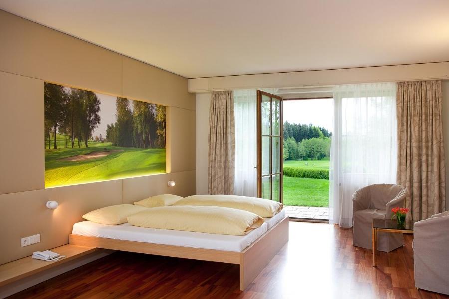 魏森贝格Golfhotel Bodensee的一间卧室设有一张大床和一个大窗户
