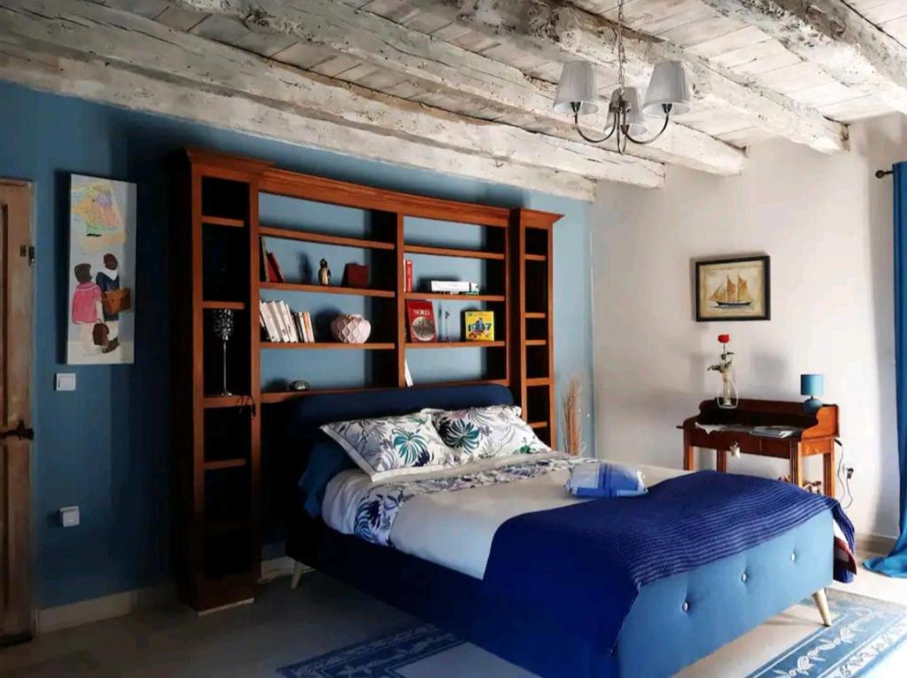 ExcideuilChez Sylvie的一间卧室设有一张床和蓝色的墙壁