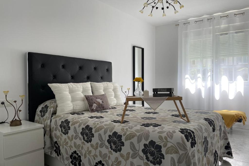 菲尼斯特雷SanMar的一间卧室配有一张大床和黑色床头板